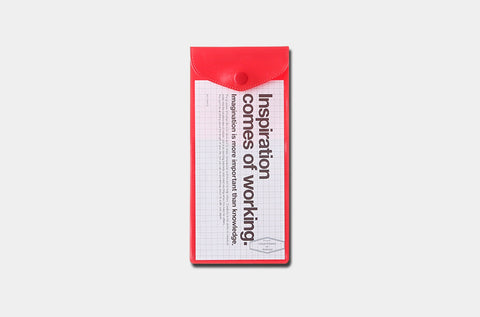 Small notebook with red cover and white pages on a light gray background